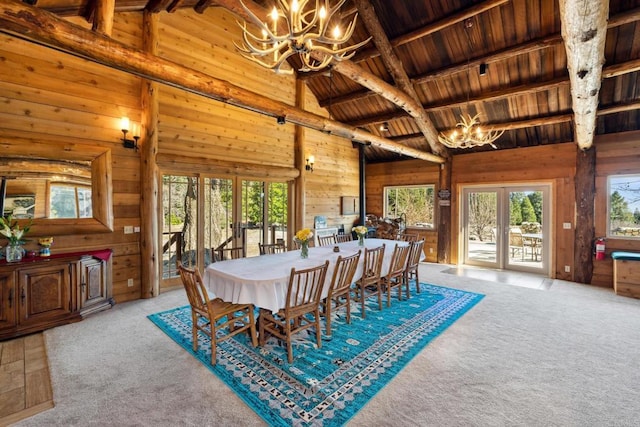 carpeted dining area with wood ceiling, beam ceiling, french doors, and a healthy amount of sunlight