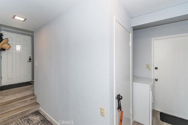 clothes washing area with light hardwood / wood-style floors and washer / dryer