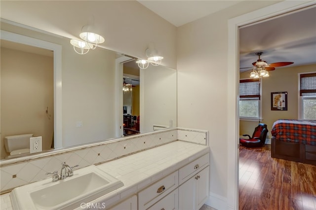 bathroom featuring ceiling fan, hardwood / wood-style floors, vanity, and toilet