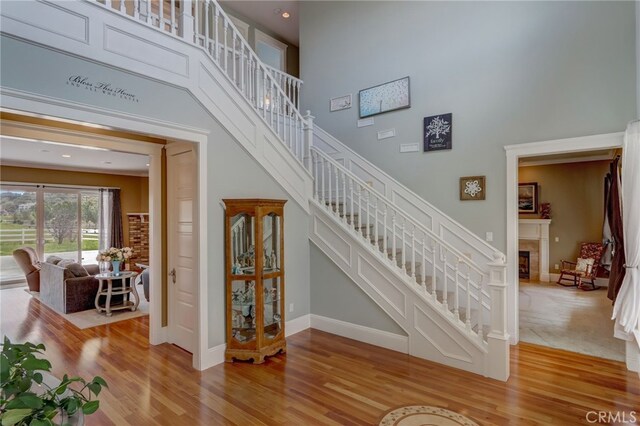 staircase featuring hardwood / wood-style floors and a towering ceiling