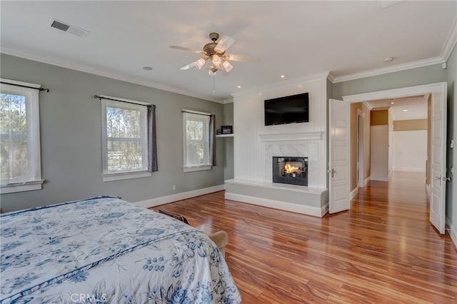 bedroom featuring multiple windows, ceiling fan, and light wood-type flooring