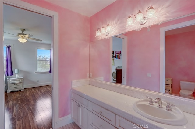 bathroom with vanity, hardwood / wood-style flooring, toilet, and ceiling fan