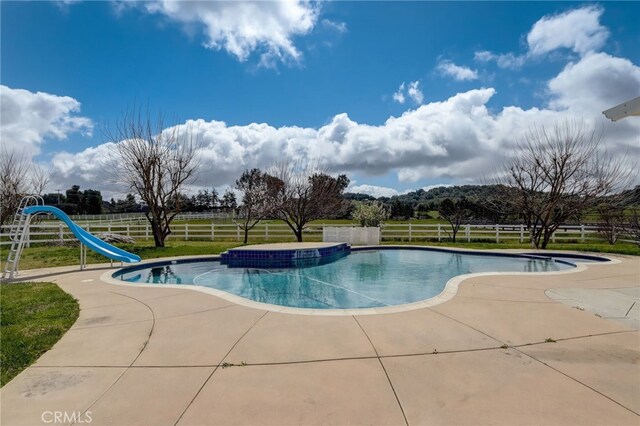 view of pool with a water slide and a patio