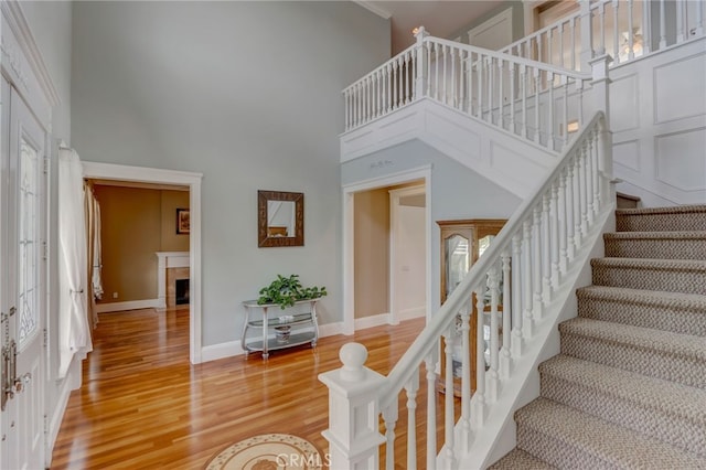 stairs with wood-type flooring and a high ceiling