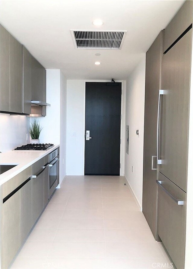 kitchen with light tile patterned floors, stainless steel appliances, gray cabinetry, and sink