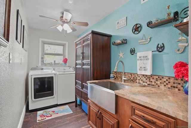 laundry room with washing machine and dryer, sink, dark wood-type flooring, and ceiling fan