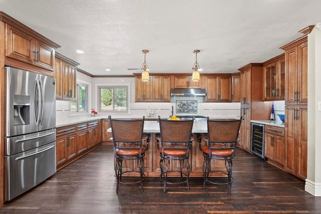 kitchen with stainless steel fridge, a kitchen island, beverage cooler, and dark hardwood / wood-style flooring