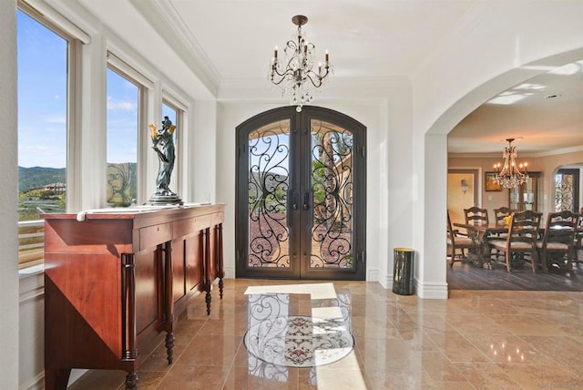 entrance foyer featuring french doors, a mountain view, an inviting chandelier, and crown molding