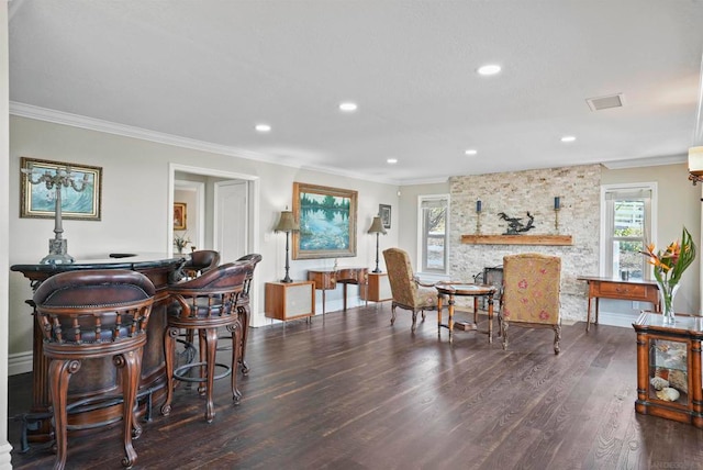 dining room featuring crown molding, a fireplace, and dark hardwood / wood-style floors