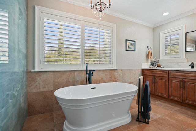 bathroom featuring tile walls, a tub to relax in, vanity, crown molding, and tile patterned floors