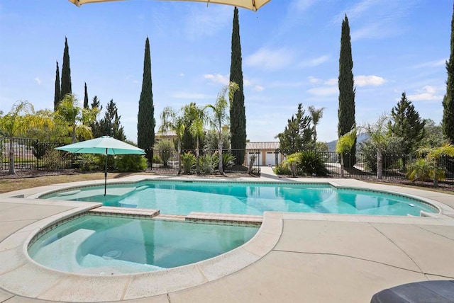 view of swimming pool featuring an in ground hot tub and a patio area