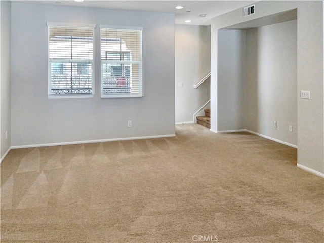 spare room with recessed lighting, carpet flooring, visible vents, baseboards, and stairs