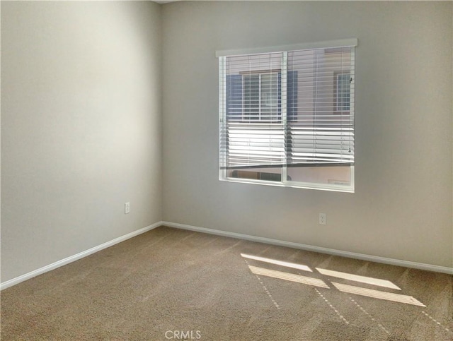 unfurnished room with baseboards and carpet flooring