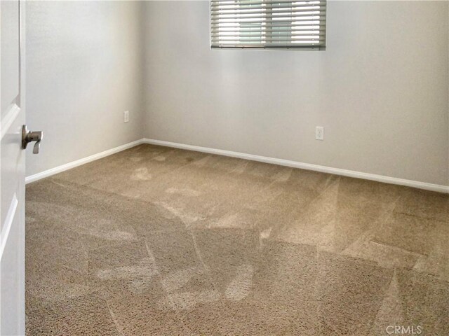 carpeted spare room with baseboards