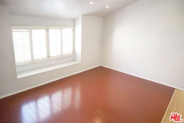 unfurnished room with dark hardwood / wood-style floors