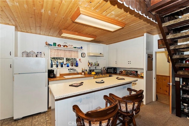 kitchen with wood ceiling, sink, white cabinets, and black appliances