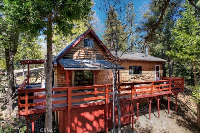 rear view of property featuring a wooden deck