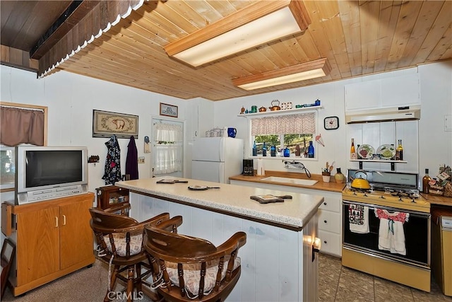 kitchen with wooden ceiling, white refrigerator, sink, white cabinetry, and range