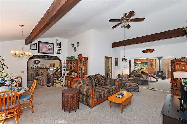 carpeted living room featuring ceiling fan with notable chandelier, lofted ceiling with beams, and a wood stove