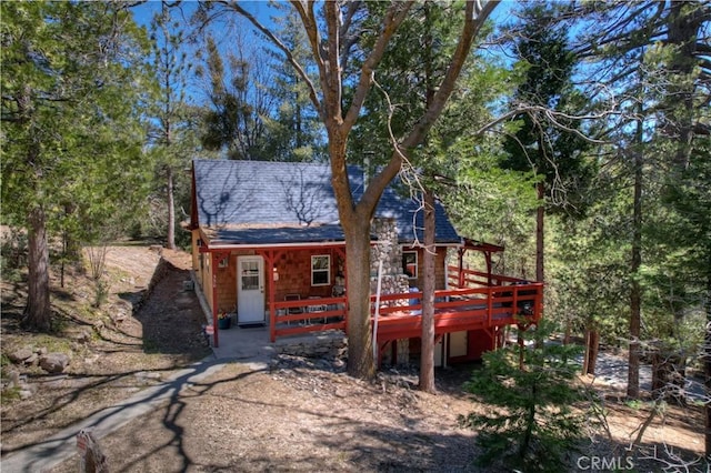 rear view of property featuring a wooden deck