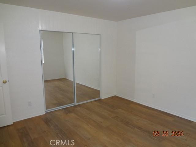 unfurnished bedroom featuring wood-type flooring and a closet