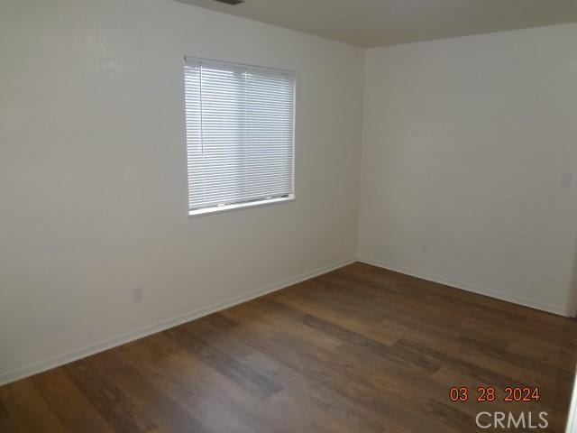 spare room featuring dark hardwood / wood-style flooring and plenty of natural light