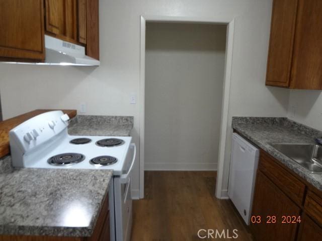 kitchen with dark hardwood / wood-style flooring, white appliances, and sink