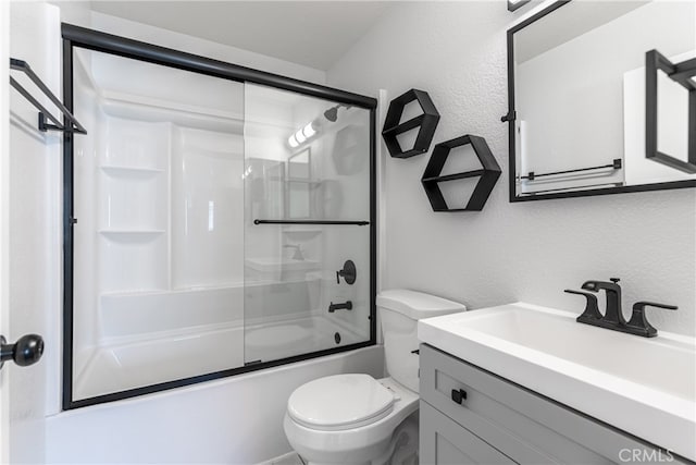 full bathroom featuring vanity, bath / shower combo with glass door, and toilet