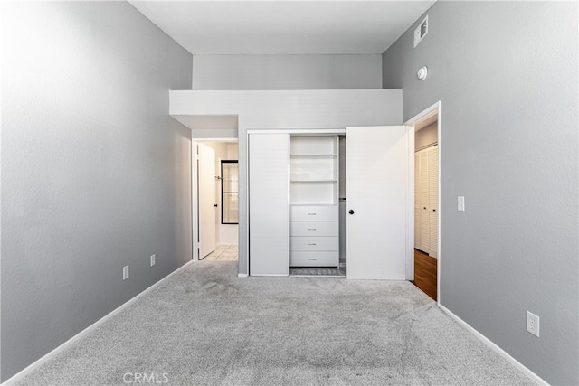 unfurnished bedroom featuring a closet and light carpet