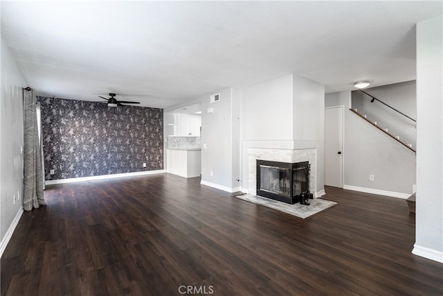 unfurnished living room featuring dark wood-type flooring, a fireplace, and ceiling fan