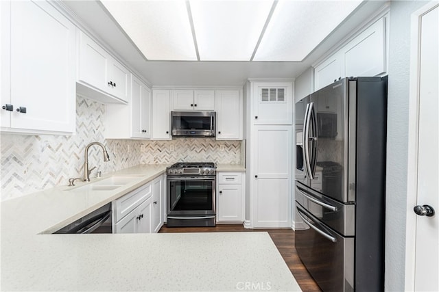 kitchen featuring tasteful backsplash, appliances with stainless steel finishes, sink, white cabinets, and dark hardwood / wood-style floors