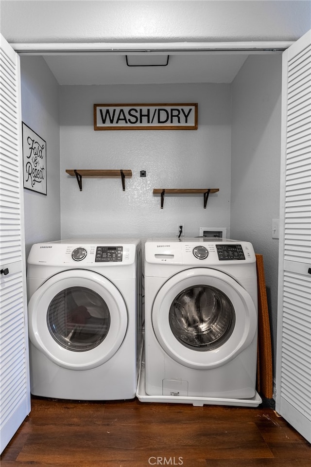 laundry room with dark hardwood / wood-style floors and washer and dryer