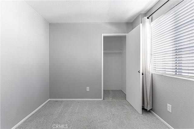 unfurnished bedroom with a closet and light colored carpet