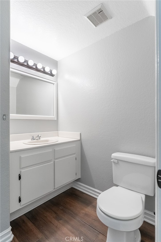 bathroom featuring vanity, hardwood / wood-style floors, and toilet