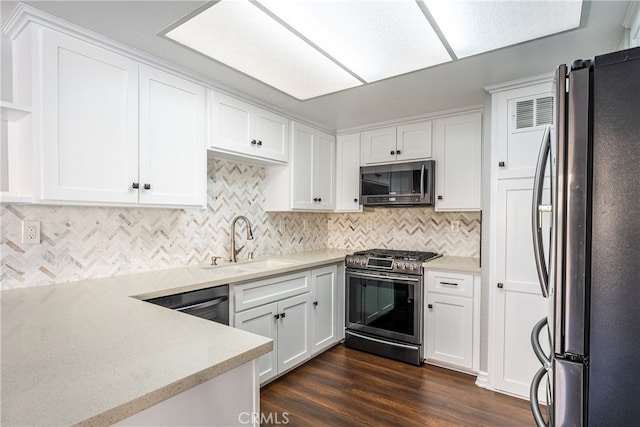 kitchen with decorative backsplash, dark hardwood / wood-style flooring, appliances with stainless steel finishes, white cabinetry, and sink