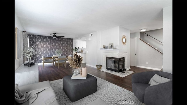 living room with a multi sided fireplace, hardwood / wood-style flooring, and ceiling fan