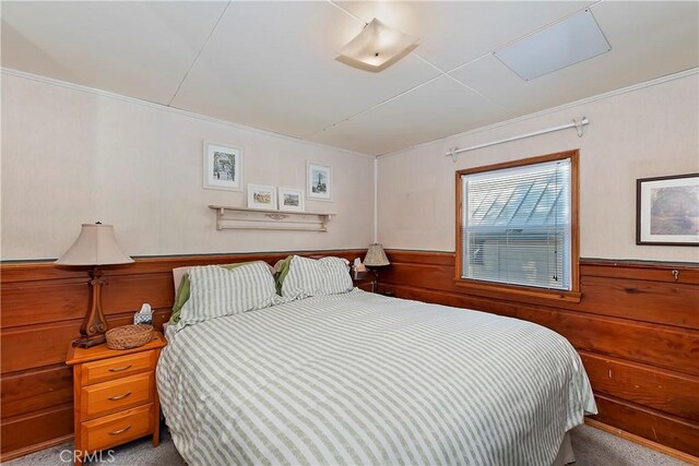 carpeted bedroom featuring wooden walls