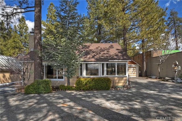 view of front of house with driveway and a chimney