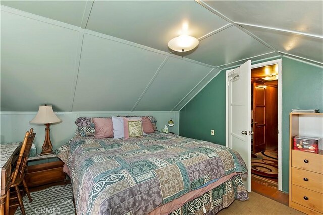 bedroom featuring lofted ceiling and carpet flooring