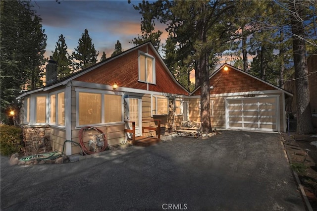 chalet / cabin featuring a garage and a chimney