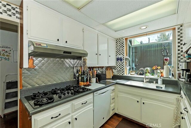 kitchen featuring dishwasher, sink, white cabinets, black gas stovetop, and decorative backsplash