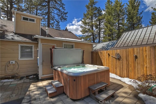 view of patio / terrace with fence and a hot tub