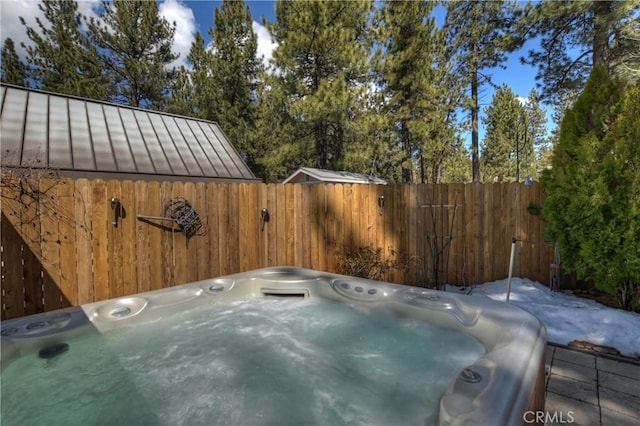 view of patio / terrace with a hot tub and fence