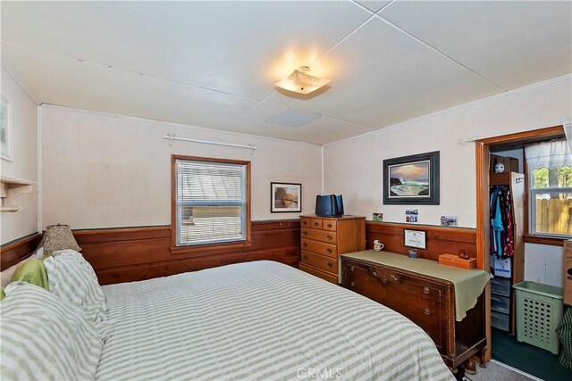 bedroom featuring wooden walls, carpet, and a closet