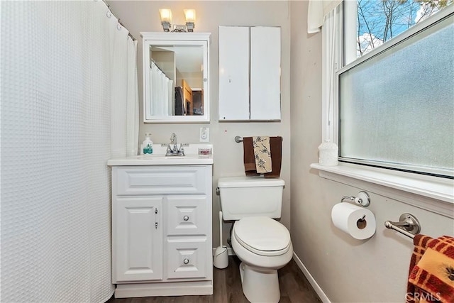 bathroom with baseboards, vanity, toilet, and wood finished floors