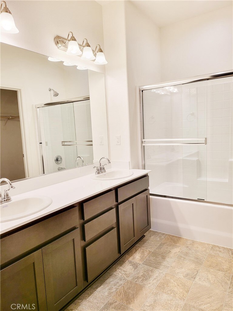 bathroom with vanity and bath / shower combo with glass door