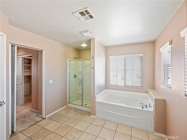 bathroom featuring tile patterned floors, separate shower and tub, and a textured ceiling