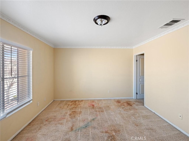 empty room with a wealth of natural light, crown molding, and light colored carpet