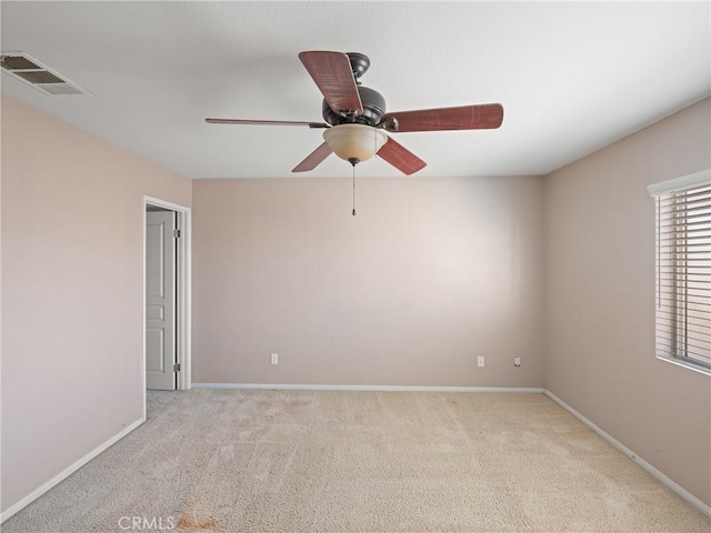 spare room featuring light carpet and ceiling fan