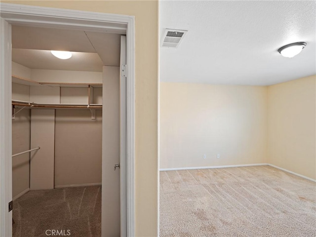 walk in closet featuring light colored carpet